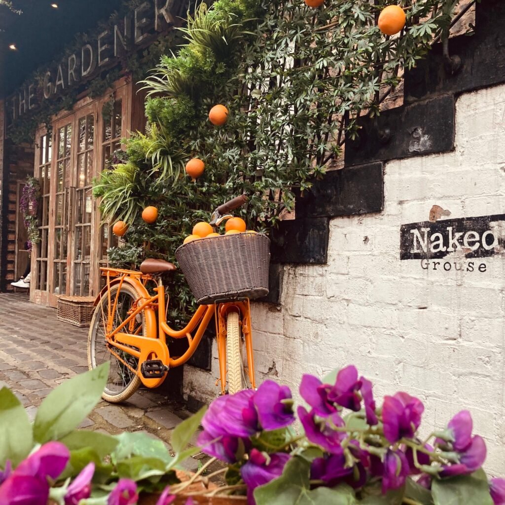 Bespoke artificial plants around the banister and stair rails with oranges create a vibrant summer display