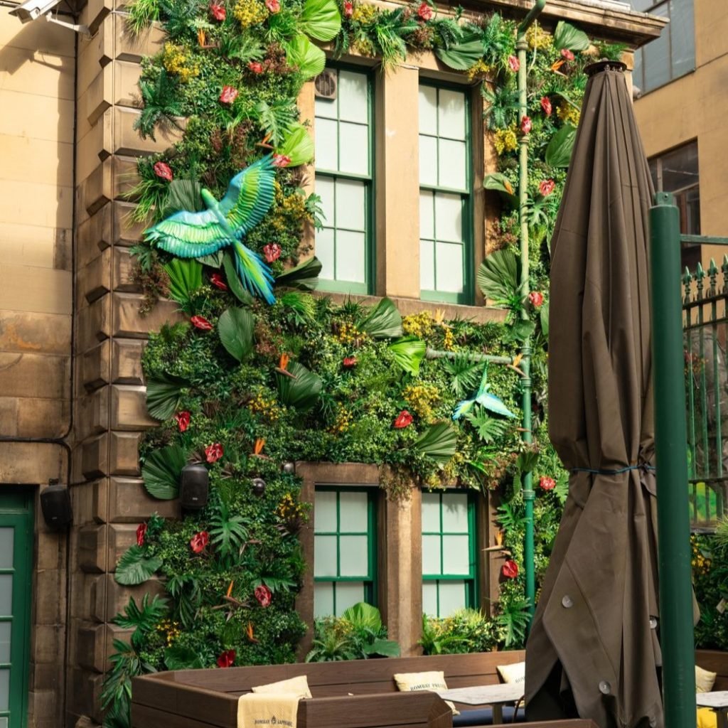 A beautiful tropical-themed display with vibrant flowers and birds at rose street gardens