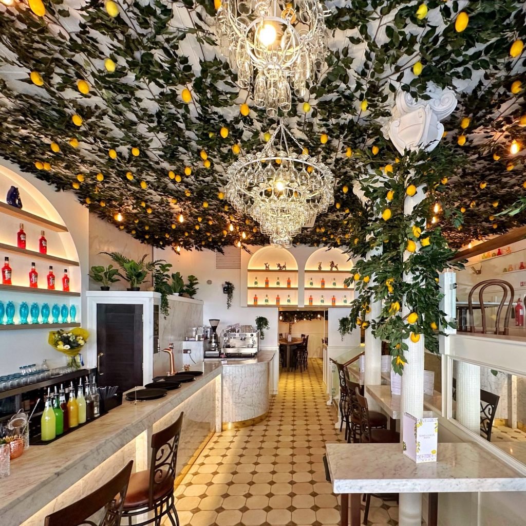 An array of artificial foliage covers the ceiling at the Santa Lucia in Glasgow, interspersed with artificial lemons to create a summery citrus vibe